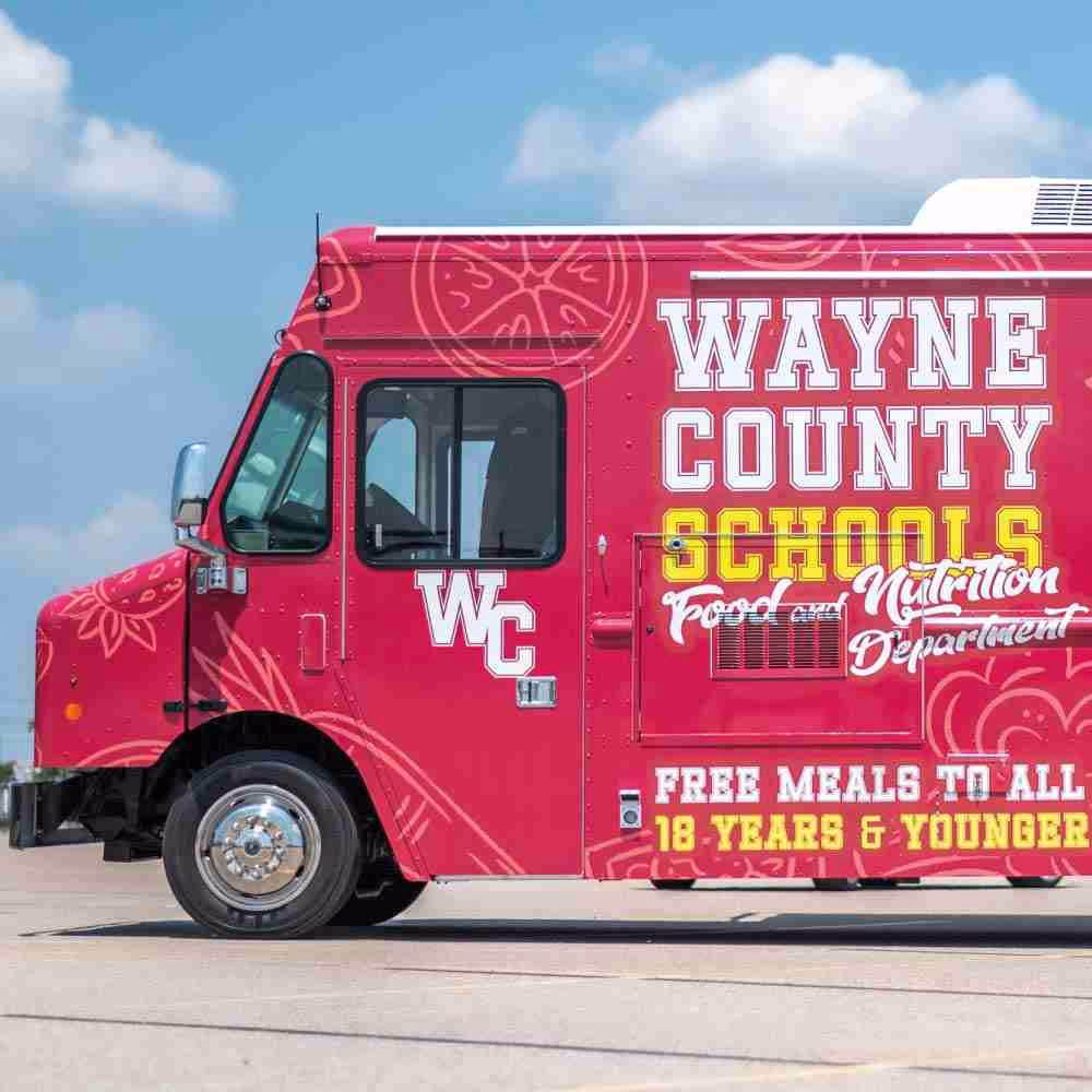 Custom-built food truck with a red vinyl wrap for Wayne County Schools.